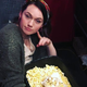 Writer kneeling by trash can full of popcorn